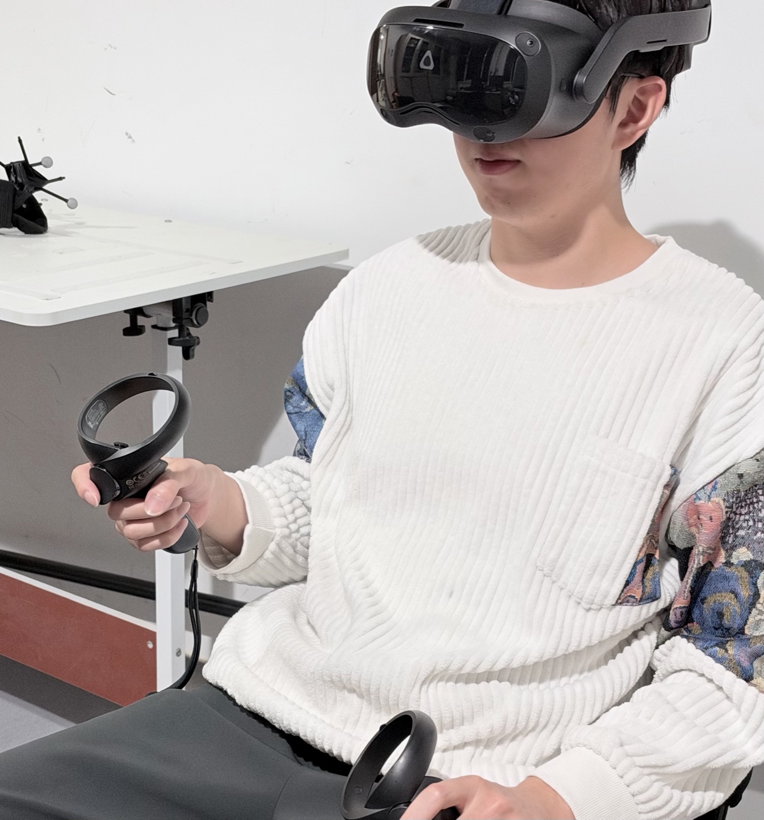 A participant wearing a virtual-reality headset and holding two controllers.
